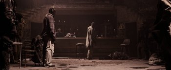 Movie still from “The Book of Eli” (2010), directed by Allen Hughes – A man standing in front of an empty bar; Wide shot, Low angle