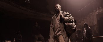 Movie still from “The Book of Eli” (2010), directed by Allen Hughes – A man with a beard is holding a bag; Medium shot, Low angle