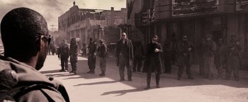 Movie still from “The Book of Eli” (2010), directed by Allen Hughes – A group of men standing on the side of the street; Wide shot, Low angle