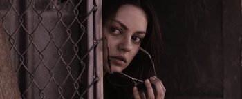 Movie still from “The Book of Eli” (2010), directed by Allen Hughes – A woman holding a pair of eye glasses in front of her face; Close Up shot, Low angle