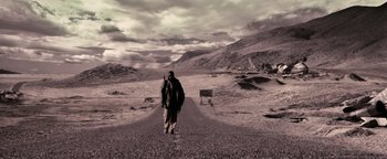 Movie still from “The Book of Eli” (2010), directed by Allen Hughes – A man walking down the middle of a road; Extreme Wide shot, Low angle