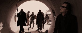 Movie still from “The Book of Eli” (2010), directed by Allen Hughes – A black and white photo of a group of soldiers; Wide shot, Over the shoulder angle
