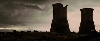Movie still from “The Book of Eli” (2010), directed by Allen Hughes – A group of people standing next to a large tower; Extreme Wide shot, Low angle