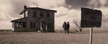 Movie still from “The Book of Eli” (2010), directed by Allen Hughes – Two people walking in front of an abandoned house; Extreme Wide shot, Low angle