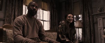 Movie still from “The Book of Eli” (2010), directed by Allen Hughes – A man and a woman sitting on a couch in front of a window; Medium shot, Over the shoulder angle