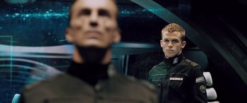 Movie still from “Pandorum” (2009), directed by Christian Alvart – A man in a green jacket standing next to another man in a green jacket; Close Up shot, Low angle