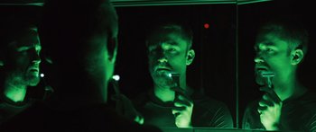 Movie still from “Pandorum” (2009), directed by Christian Alvart – A man is looking at himself in the mirror; Close Up shot, Low angle