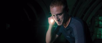 Movie still from “Pandorum” (2009), directed by Christian Alvart – A man is holding a flashlight in the dark; Close Up shot, Low angle