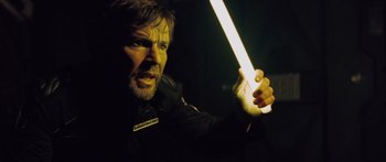 Movie still from “Pandorum” (2009), directed by Christian Alvart – A man holding a light saber in a dark room; Close Up shot, Low angle