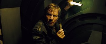 Movie still from “Pandorum” (2009), directed by Christian Alvart – A man holding a knife in a dark room; Close Up shot, Low angle