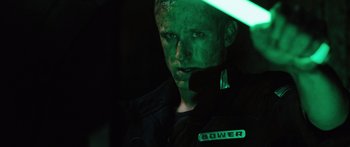 Movie still from “Pandorum” (2009), directed by Christian Alvart – A man in a black jacket and a green light; Close Up shot, High angle