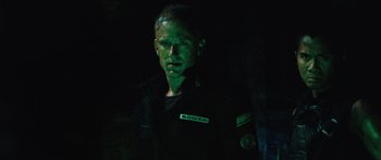 Movie still from “Pandorum” (2009), directed by Christian Alvart – A man in a black shirt and green shirt; Close Up shot, Low angle