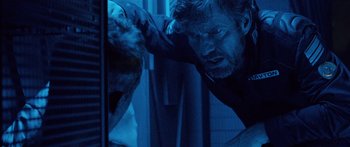Movie still from “Pandorum” (2009), directed by Christian Alvart – A man in a dark room reaching for something; Close Up shot, Over the shoulder angle