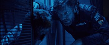 Movie still from “Pandorum” (2009), directed by Christian Alvart – A man looking at a cat in a dark room; Close Up shot, Over the shoulder angle