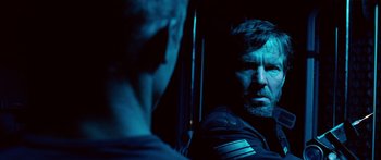 Movie still from “Pandorum” (2009), directed by Christian Alvart – A man with a beard is looking into a mirror; Close Up shot, Over the shoulder angle