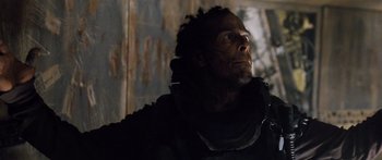 Movie still from “Pandorum” (2009), directed by Christian Alvart – A man with a beard is standing in the dark; Close Up shot, Low angle