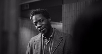 Movie still from “Paris, 13th District” (2021), directed by Jacques Audiard – A black and white photo of a man wearing a jacket; Close Up shot, Low angle