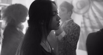 Movie still from “Paris, 13th District” (2021), directed by Jacques Audiard – A young woman with long black hair is looking into the distance; Close Up shot, Over the shoulder angle