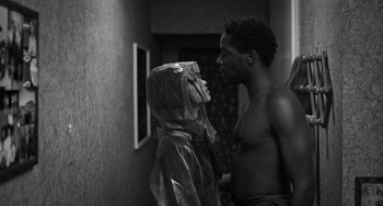 Movie still from “Paris, 13th District” (2021), directed by Jacques Audiard – A man and a woman are standing next to each other in a room; Medium shot, Over the shoulder angle