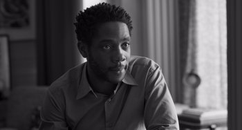 Movie still from “Paris, 13th District” (2021), directed by Jacques Audiard – A black and white photo of a man looking at the camera; Close Up shot, Low angle