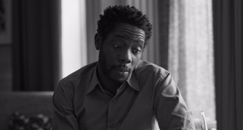 Movie still from “Paris, 13th District” (2021), directed by Jacques Audiard – A black and white photo of a man with a beard; Close Up shot, Low angle