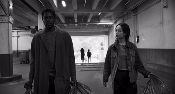 Movie still from “Paris, 13th District” (2021), directed by Jacques Audiard – A man and a woman walking down a street; Wide shot, Low angle