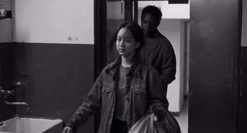 Movie still from “Paris, 13th District” (2021), directed by Jacques Audiard – A man and a woman walking down a hall way; Medium shot, Over the shoulder angle