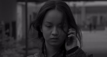 Movie still from “Paris, 13th District” (2021), directed by Jacques Audiard – A young woman holding a cell phone up to her ear; Close Up shot, Low angle