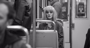Movie still from “Paris, 13th District” (2021), directed by Jacques Audiard – A woman sitting on a bus looking at the camera; Close Up shot, High angle