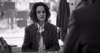Movie still from “Paris, 13th District” (2021), directed by Jacques Audiard – A woman sitting at a table in front of a mirror; Medium shot, Over the shoulder angle