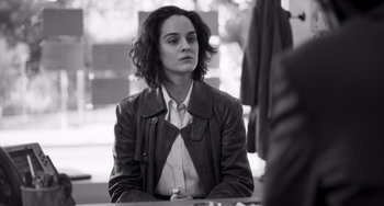 Movie still from “Paris, 13th District” (2021), directed by Jacques Audiard – Black and white photograph of a woman sitting at a table; Medium shot, Over the shoulder angle