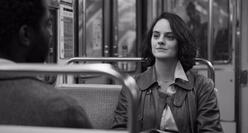 Movie still from “Paris, 13th District” (2021), directed by Jacques Audiard – A woman sitting on a bus with her head turned to the side; Close Up shot, Over the shoulder angle