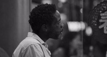 Movie still from “Paris, 13th District” (2021), directed by Jacques Audiard – A black and white photo of a man looking to his left; Close Up shot, Low angle