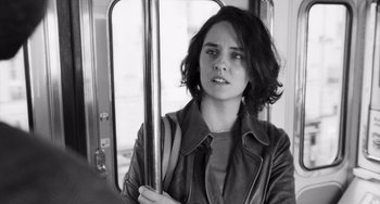 Movie still from “Paris, 13th District” (2021), directed by Jacques Audiard – A woman holding onto the handle of a train; Close Up shot, Over the shoulder angle