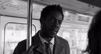 Movie still from “Paris, 13th District” (2021), directed by Jacques Audiard – A black and white photo of a man in a suit and tie; Close Up shot, Low angle