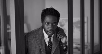 Movie still from “Paris, 13th District” (2021), directed by Jacques Audiard – A black and white photo of a man in a suit and tie; Close Up shot, Low angle