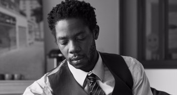 Movie still from “Paris, 13th District” (2021), directed by Jacques Audiard – A black and white photo of a man in a vest and tie; Close Up shot, Low angle