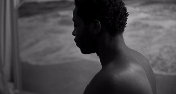 Movie still from “Paris, 13th District” (2021), directed by Jacques Audiard – A black and white photo of a man's face; Close Up shot, High angle