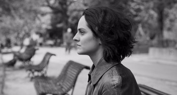 Movie still from “Paris, 13th District” (2021), directed by Jacques Audiard – Black and white photograph of a woman in a park; Close Up shot, Over the shoulder angle