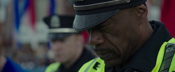 Movie still from “Patriots Day” (2016), directed by Peter Berg – A man in a police uniform looking down; Close Up shot, Over the shoulder angle