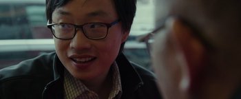 Movie still from “Patriots Day” (2016), directed by Peter Berg – A young man wearing glasses and a leather jacket; Close Up shot, Over the shoulder angle