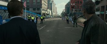 Movie still from “Patriots Day” (2016), directed by Peter Berg – A group of people standing on the side of a road; Medium shot, Over the shoulder angle
