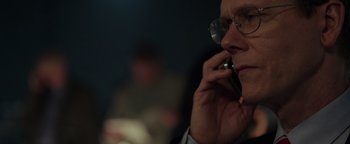 Movie still from “Patriots Day” (2016), directed by Peter Berg – A man with glasses is talking on a cell phone; Close Up shot, Over the shoulder angle