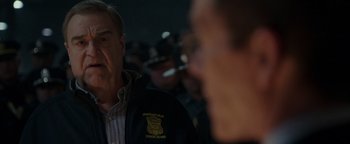 Movie still from “Patriots Day” (2016), directed by Peter Berg – A man wearing a police uniform is talking to another man; Close Up shot, Over the shoulder angle