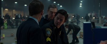 Movie still from “Patriots Day” (2016), directed by Peter Berg – A group of men standing next to each other in a room; Close Up shot, Over the shoulder angle