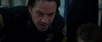 Movie still from “Patriots Day” (2016), directed by Peter Berg – A person wearing a police uniform; Close Up shot, Over the shoulder angle