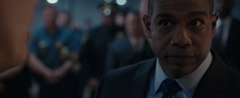 Movie still from “Patriots Day” (2016), directed by Peter Berg – A person wearing a suit and tie; Close Up shot, Over the shoulder angle