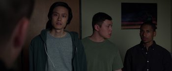 Movie still from “Patriots Day” (2016), directed by Peter Berg – Two young men standing next to each other in front of a wall; Medium shot, Low angle