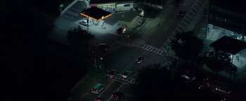 Movie still from “Patriots Day” (2016), directed by Peter Berg – Cars are stopped at a gas station at night; Extreme Wide shot, High angle