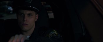 Movie still from “Patriots Day” (2016), directed by Peter Berg – A police officer sitting in the back of a car; Close Up shot, Over the shoulder angle